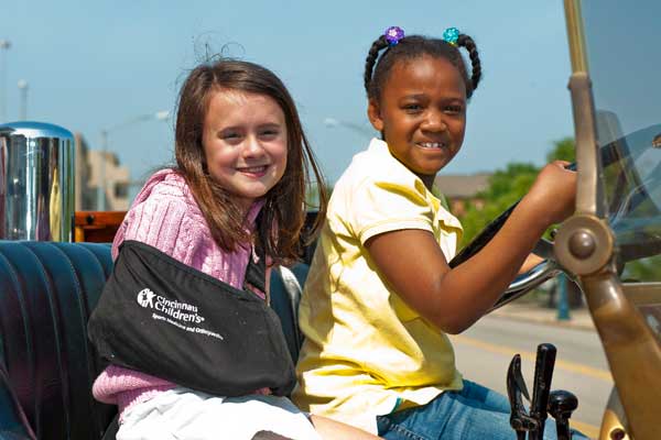 Two girls riding in a motorcade